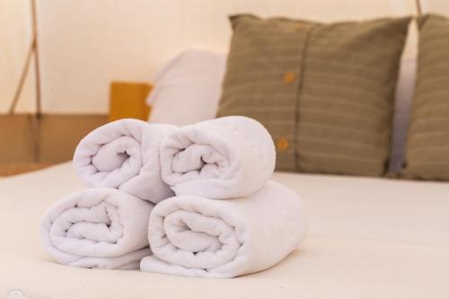 een stapel handdoeken bovenop een bed bij Respira Glamping Montseny in Montseny
