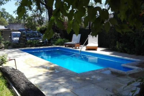 a swimming pool in a yard with two lounge chairs at CABAÑAS VILLA CLUB 4 cerca del aeropuerto el palomar in Hurlingham