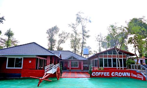 a red house with a coffee company on the water at Coffee Crown Homestay - Water Falls, Trek, Home Food, Estate in Sakleshpur