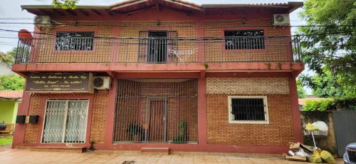 a red brick building with a balcony on it at Casa duplex en Área 4 CDE in Ciudad del Este