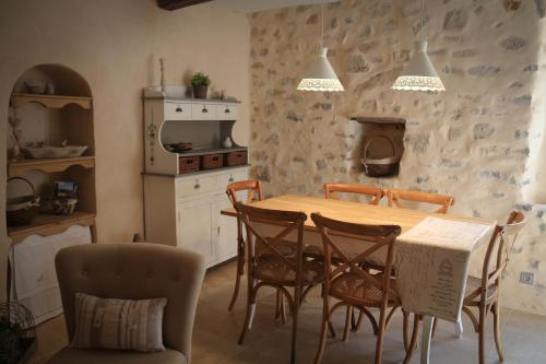 - une cuisine avec une table et des chaises en bois dans l'établissement Gite Marceline, à Saint-Guilhem-le-Désert