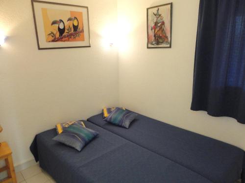 - une chambre avec un lit bleu et 2 oreillers dans l'établissement SOPRALAND Joli T3 piscine proche plage Richelieu Cap d'Agde, au Cap d'Agde