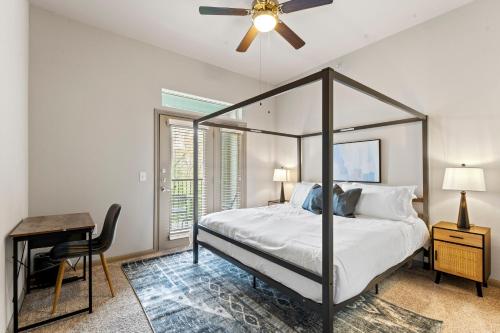 um quarto com uma cama, uma ventoinha de tecto e uma secretária em Spacious 2BR King Bed Suites Close to Downtown and Airport em Austin