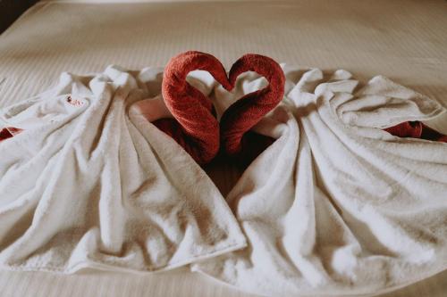 two red hearts are laying on a bed at Shiva's Beach Cabanas in Tangalle