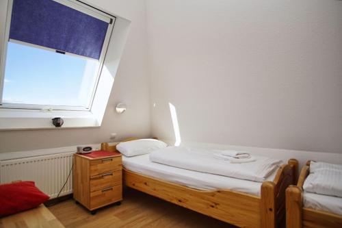 a small bedroom with a bed and a window at hafennahe Maisonette-Wohnung mit Meerblick, Balkon - Hafenhäuser Breege FeWo 03 in Breege