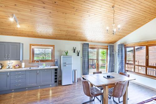a kitchen with a wooden ceiling and a table at Mountain Ash Lodge with Hot Tub in Cupar