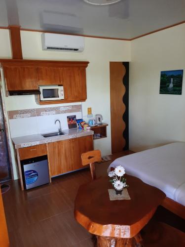 Binalonan Transient/GUESTHOUSE (PENSION GLAYDIE) في Binalonan: غرفة صغيرة مع مطبخ وسرير وطاولة