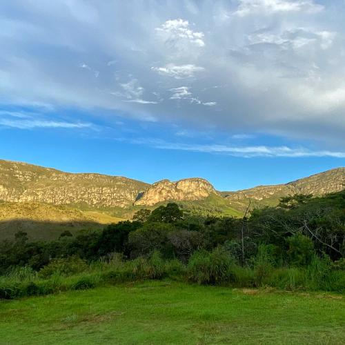 a view of a mountain range with a green field at Pouso do Elefante in Serra do Cipo