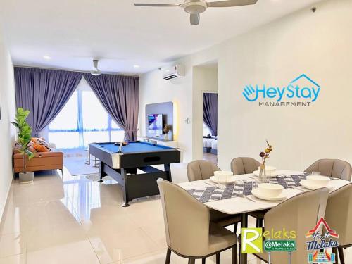 a living room with a ping pong table and a dining room with a pool at The Apple Residence By Heystay Management in Melaka