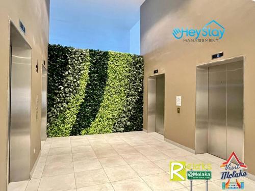 a large green wall in a hallway in a building at The Apple Residence By Heystay Management in Melaka