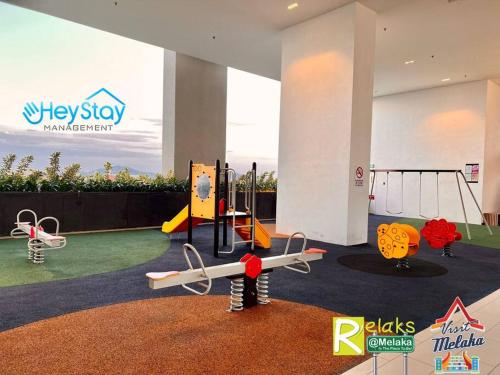 a play area with swings and a playground at The Apple Residence By Heystay Management in Melaka
