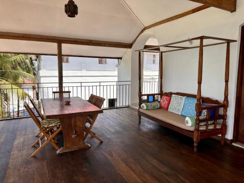 uma sala de estar com uma mesa, uma cama e uma secretária em David Livingstone's Home em Zanzibar