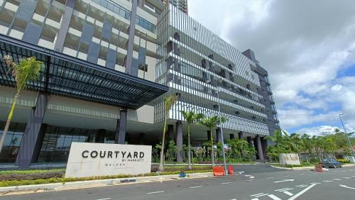 a building with a court yard sign in front of it at The Apple Residence By Heystay Management in Melaka