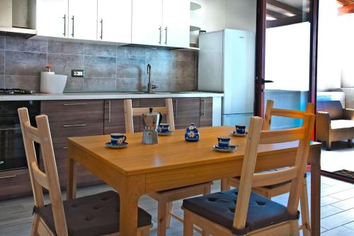 una mesa de madera y sillas en la cocina en Casa Basilio con bellissima terrazza vista isole, en Lipari