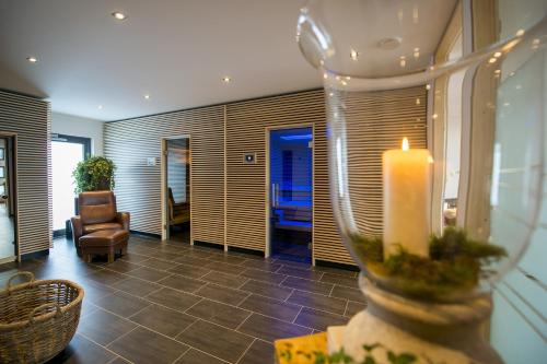 uma sala de estar com uma vela e uma cadeira em Landidyll Hotel zum Freden em Bad Iburg