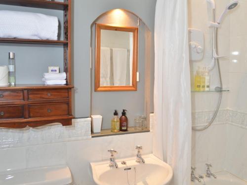 a bathroom with a sink and a shower with a mirror at Blarcreen in Oban