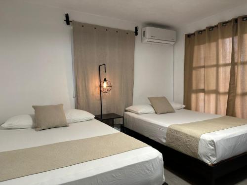 a bedroom with two beds and a window at Casa Malva Sweet Stay in Guanajuato