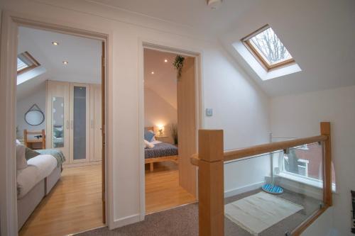 ein Wohnzimmer mit einem Dachfenster und ein Zimmer mit einem Sofa in der Unterkunft Sealock Mews by Property Promise in Cardiff
