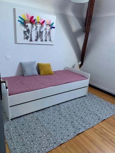 - un lit dans une chambre avec une photo sur le mur dans l'établissement Maison de campagne chez Tatiana, à Adé