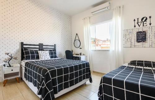 a bedroom with two beds and a window at Espaço Agradável, Rio de Janeiro in Rio de Janeiro