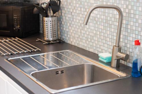 a stainless steel sink in a kitchen next to a microwave at Sealock Mews by Property Promise in Cardiff