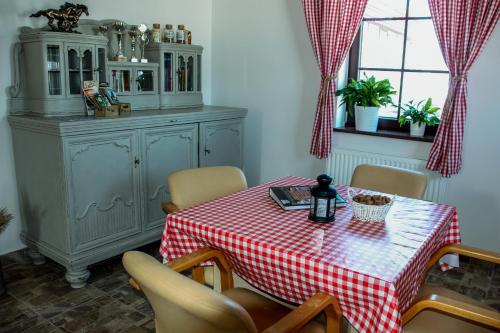 a dining room table with a red and white checkered table cloth at Storczykowe Wzgórze in Paszowice