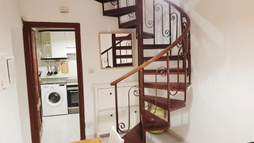 una escalera de caracol en una cocina con lavadora en Casa pequeña y acogedora en casco histórico, en Pobra do Caramiñal