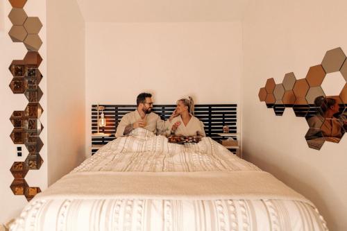 a man and a woman sitting on a bed at La Love Story in Hastière-par-delà