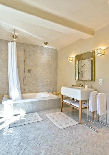 une salle de bain avec une baignoire et un lavabo dans l'établissement Château Marteret, à Vic-Fezensac