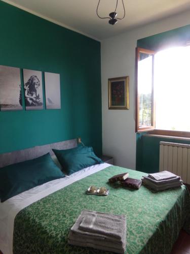 1 dormitorio con 1 cama con pared verde en Il campanile, en Cavriglia