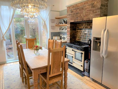 a kitchen with a wooden table and a refrigerator at Victorian Villa close to Liverpool City Centre in Liverpool