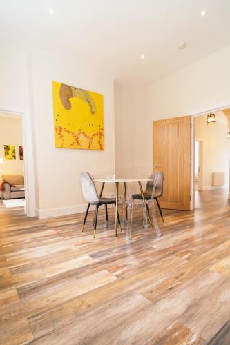 a dining room with a table and chairs and a painting at The Milkmans Residence in Bournemouth
