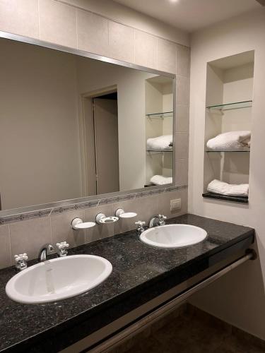 baño con 2 lavabos y espejo grande en Gualeguaychú Golf y verdes en Gualeguaychú