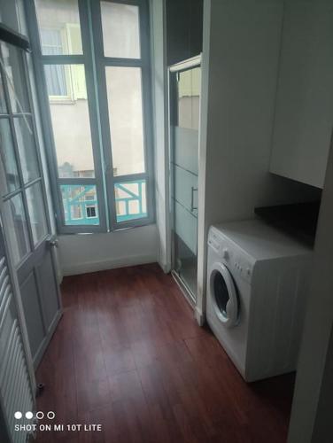 a laundry room with a washing machine and a window at Spacieux et lumineux 2 pièces in Roquebillière