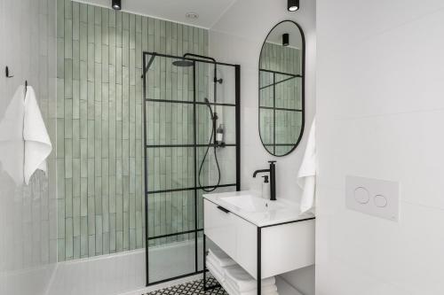 a bathroom with a shower and a sink and a mirror at Apartament Aleja 22 in Poznań