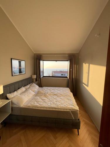 奧帕蒂亞的住宿－Opatija Apartment - Ocean Suite & Sea Breeze，一间卧室设有一张床和一个大窗户