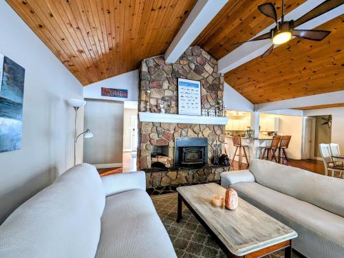 a living room with couches and a stone fireplace at Cozy Escape, Kawarthas Cottage With Sauna in Buckhorn