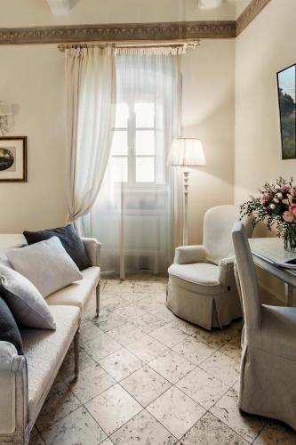 a living room with two couches and a table and a window at Monastero di Cortona Hotel & Spa in Cortona