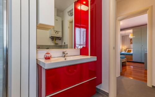 una cocina con armarios rojos y fregadero en Apartment Green Pula, Family friendly, Comfortable, free parking and WiFi, en Pula
