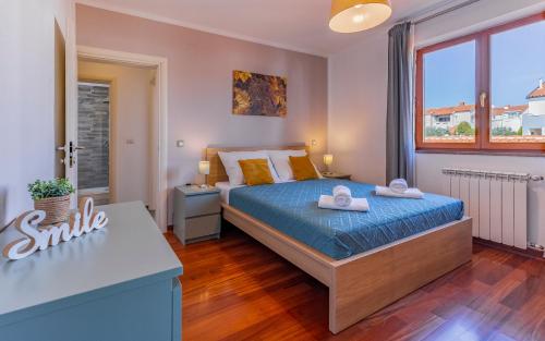 1 dormitorio con 1 cama con sábanas azules y almohadas amarillas en Apartment Green Pula, Family friendly, Comfortable, free parking and WiFi, en Pula