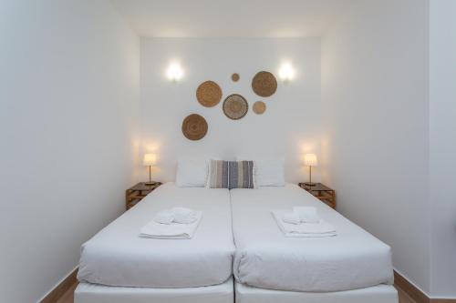a bedroom with two white beds and two lamps at FishermenApartments - Carcavelos 1 in Carcavelos