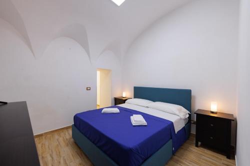een slaapkamer met een blauw bed met 2 handdoeken erop bij Casa di Nicola - Sciacca in Sciacca