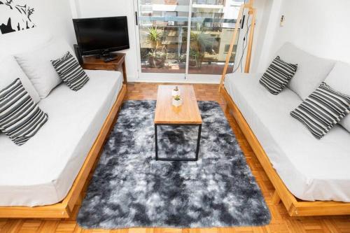 Sala de estar con 2 sofás blancos y mesa de centro en Arevalo - 1 Bd in Las Cañitas en Buenos Aires