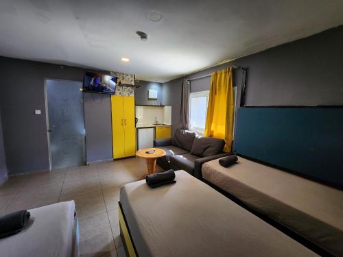 een woonkamer met 2 bedden en een bank bij Amdar Hostel in Eilat