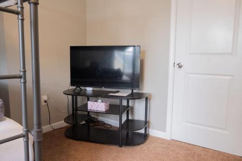 einen Fernseher auf einem schwarzen Stand in einem Zimmer in der Unterkunft New 4 Bedroom House for Downtown Travelers!!! in Indianapolis
