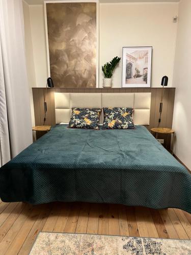 a bedroom with a bed with a green bedspread at Guest house in Dobele city center- Pilsētas Māja in Dobele