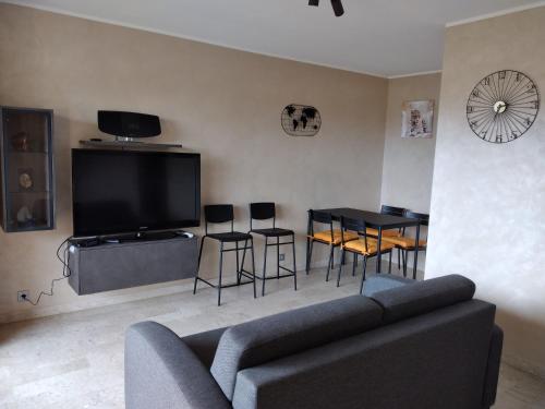 a living room with a couch and a table and chairs at Studio entièrement rénové coté plage avec garage in Roquebrune-Cap-Martin