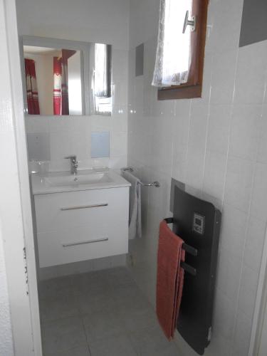 un bagno bianco con lavandino e specchio di Montagne a Savines