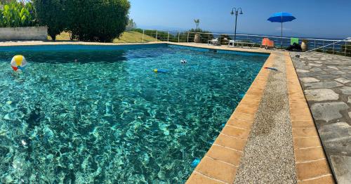 una piscina con agua azul claro y una sombrilla en Aegean Pearl en Possidi