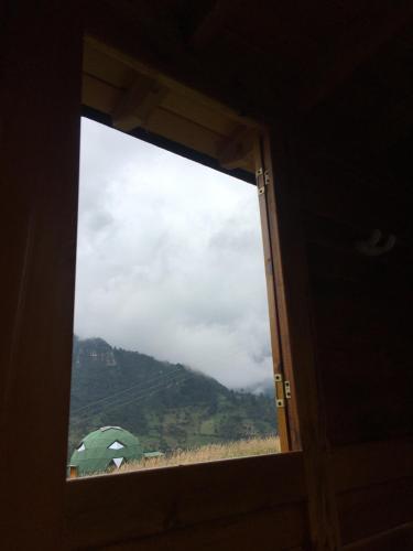 a window with a view of a mountain at Glamping domo el colibrí in Choachí